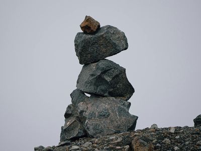 A stack of balanced stones near a workout area.