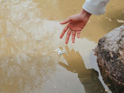 Close-up of a hand reaching for a water bottle.